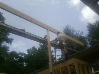 Carpenter setting a ridge beam over a new addition frame — Ice Dam Removal by Roofing Brothers in Kitzmiller