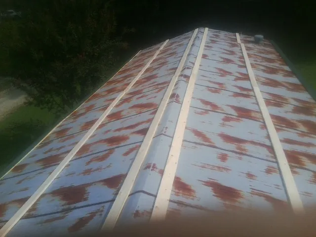 Rusted metal roof panels with new wood purlins before replacement — Storm Damage Roof Repair in Kitzmiller by Roofing Brothers