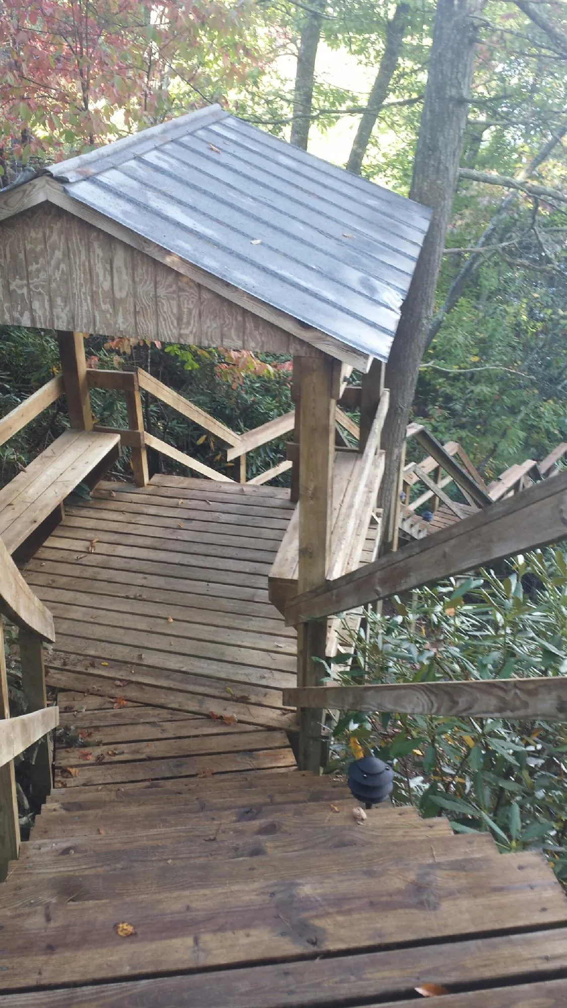 Metal roofed shelter over wooden steps on a wooded walkway — Skylight Repair & Installation work by our crew in Kitzmiller