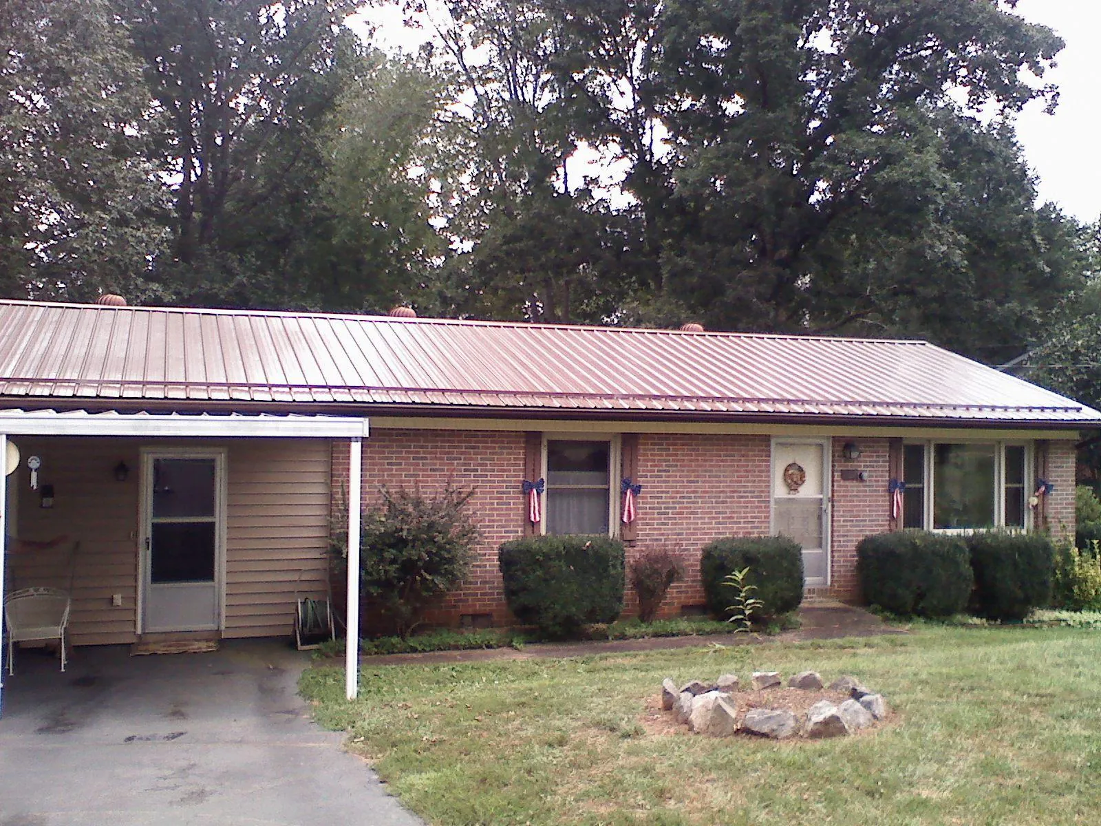 Bronze metal roof and carport on a brick ranch home — Roof Repair work by our crew in Kitzmiller